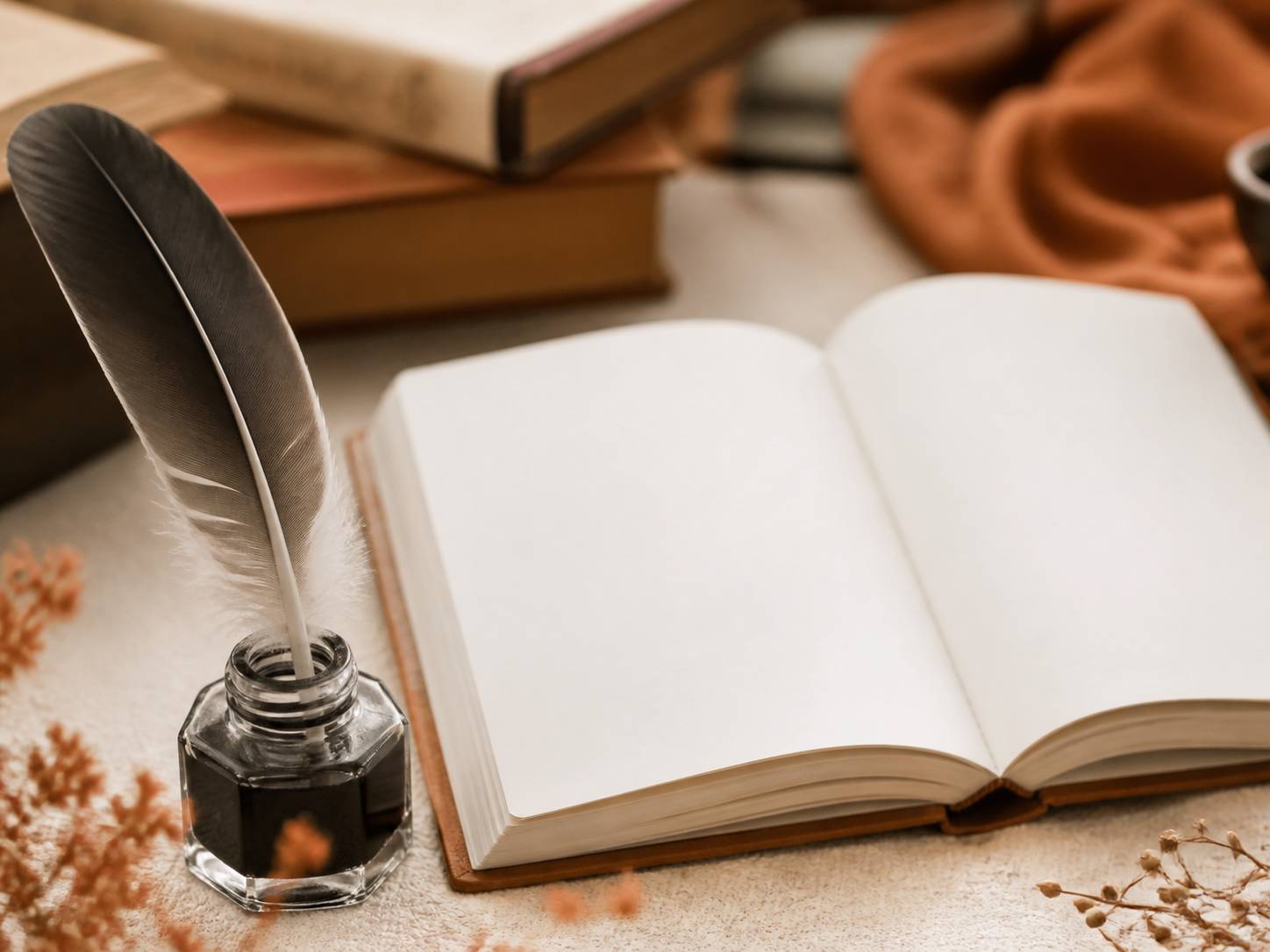 Plume posée dans un encrier avec un carnet ouvert aux pages blanches